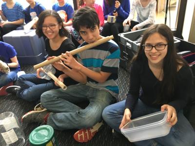 Students demonstrate instruments made from recycled materials